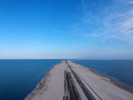 Drone photo of the marker value dike that connects Enkhuizen with lelystad. The sand has been sprayed for dyke improvement and a new nature area has also been created.の写真素材
