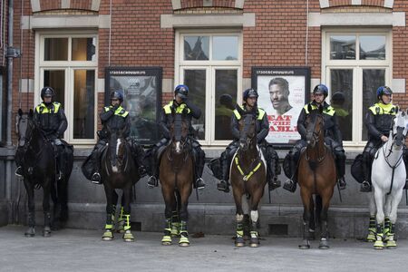 AMSTERDAM, HOLLAND - MAY 16, 2019: Police officers in uniform on their horses with protection for...