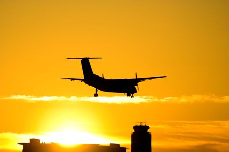 Airplane landing during the sunsetの写真素材