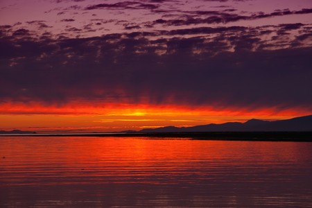Sunset on a shore and a mountain in the backgroundの写真素材