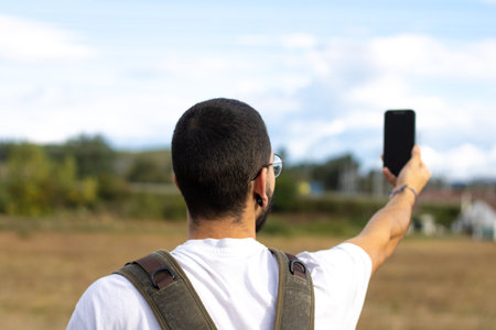 young man taking picture with mobile phoneの写真素材