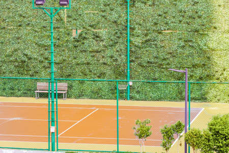 Orange color lawn tennis court partial view with green patch wallsの写真素材