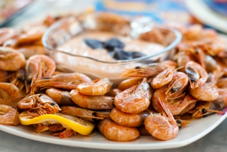 Small cooked shrimps with lemon on a plate with dipping sauceの写真素材