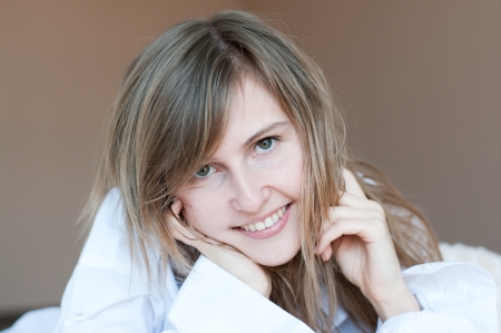 Beautiful young girl with dark-blond hair in a white shirtの写真素材