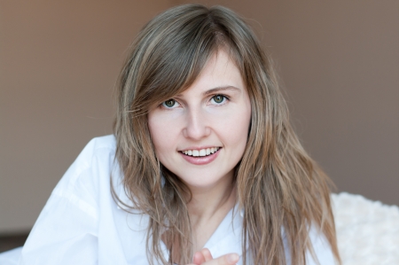 Beautiful young girl with dark-blond hair in a white shirtの写真素材