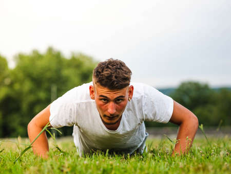 A shallow focus shot of a Caucasian male doing workout in a park