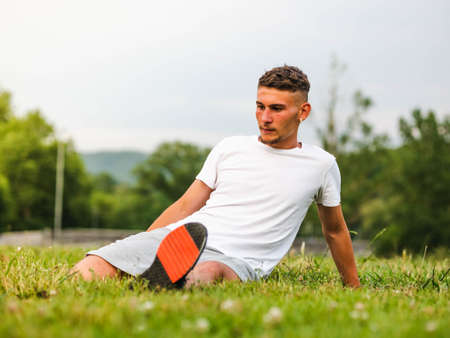 A young Caucasian man wearing earphones and working out near the bright yellow wallの写真素材