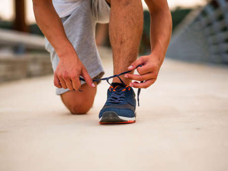 person tying shoe before trainingの写真素材