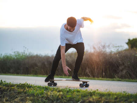 A shallow focus shot of handsome Caucasian male riding a skateboard at outdoors