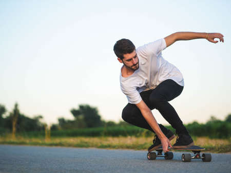 A shallow focus shot of handsome Caucasian male riding a skateboard at outdoorsの写真素材