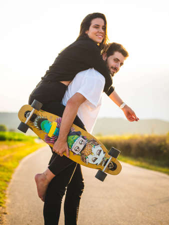A young Caucasian couple learning to skate in the street, A shallow focus shot of a beautiful lovely couple having fun togetherの写真素材