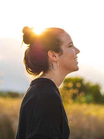 A vertical shot of a young Caucasian woman during the sunsetの写真素材