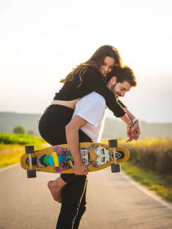 A young Caucasian couple learning to skate in the street, A shallow focus shot of a beautiful lovely couple having fun togetherの写真素材