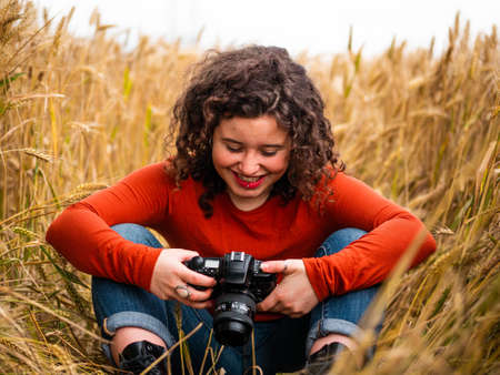 A shallow focus shot of a beautiful young female with a professional photo cameraの写真素材