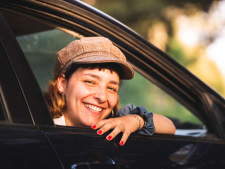 A picture of a brunette female in a black car with an amazing smileの写真素材