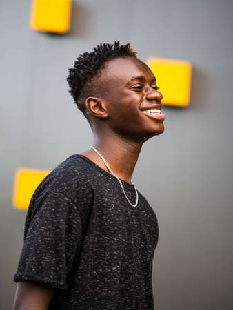 portrait of a young black male on a gray wall backgroundの写真素材
