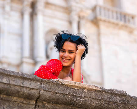 young female with a red dress. Cheerful curly hair girlの写真素材