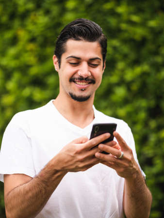 Man looking at his cellphone smartphone making selfieの写真素材