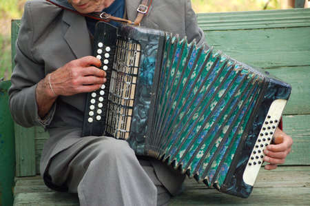 An elderly person playing on old accordionの写真素材