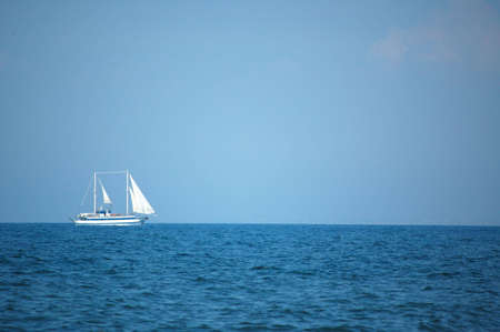 Serene scene: A sailboat at sea horizonの写真素材