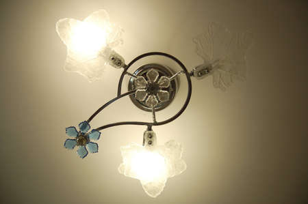 Lustre with two switched on and one switched off saving light bulbsの写真素材