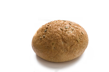Round wheat white bread with bran and pumpkin seeds on white backroundの写真素材