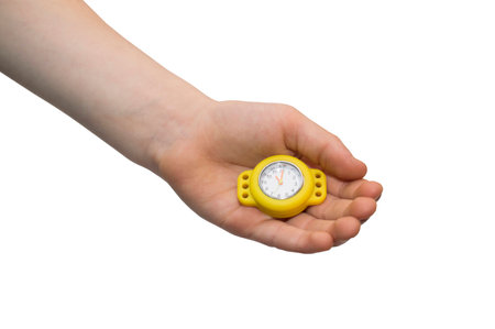 Yellow watch in the child hand isolated on white background