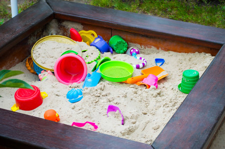 Nursery sandbox on the playground with sand bucket, rake, shovel, sieve and other equipment for sand workの写真素材
