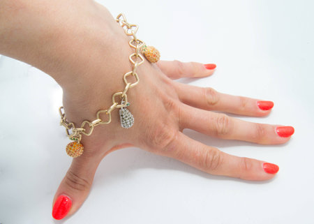 Graceful golden bracelet on woman hand on grey backgroundの写真素材