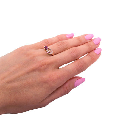 Golden ring with dark red gemstone - garnet  and few diamonds on woman's hand isolated on white backgroundの写真素材