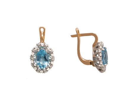 Golden earrings with blue gem - topaz  and few diamonds isolated on white backgroundの写真素材