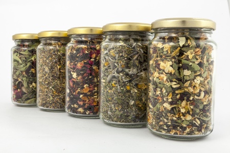 A range of transparent glass jars of different herbs の写真素材