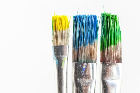 paint brushes with green yellow and blue paint