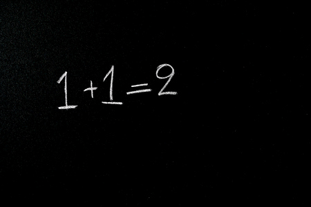 one and one equals two is written on blackboardの写真素材