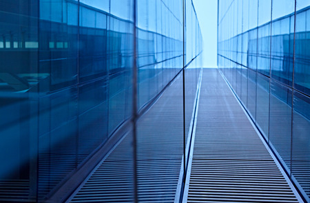 Abstract image of the facade of a modern high rise building covered in reflective plate glassの写真素材