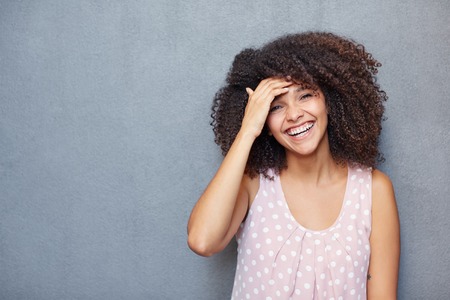 A young woman laughing against a gray backgroundの写真素材