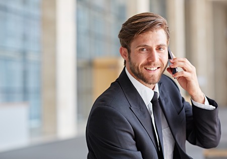 Portrait of a corporate executive smiling while talking on his phoneの写真素材