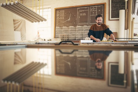 Professional craftsman working with skill and concentration in his naturally lit studio