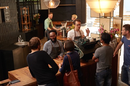 High angle view of three professional baristas working behind the counterの写真素材