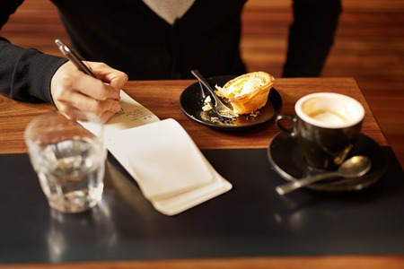 Cropped image of an unrecognizable man sitting in a stylish coffee shopの写真素材