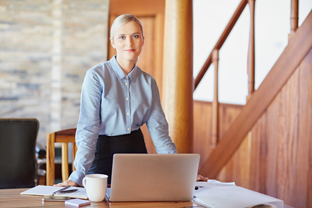Portrait of a young businesswoman at her desk, looking in to the cameraの写真素材