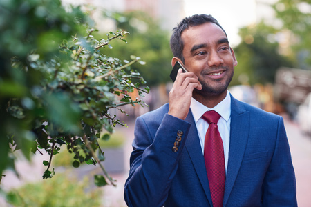 Businessman talking on a cellphone while walking in the cityの写真素材