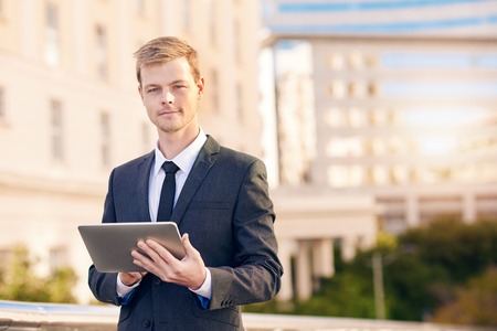 Portrait of a businessman using a digital tablet with the city in the backgroundの写真素材