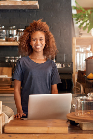 Portrait of an attractive young woman using a laptop while working in a cafeの写真素材