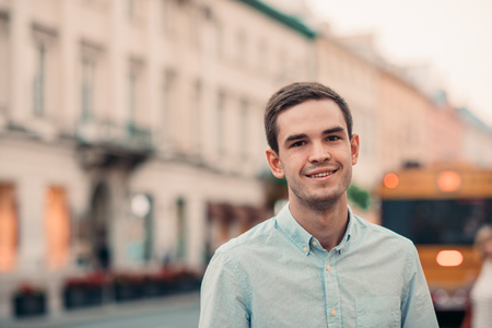 Smiling young man standing in the cityの写真素材