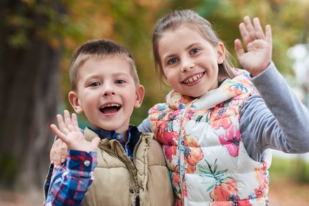 Cute little kids waving hello in the parkの写真素材