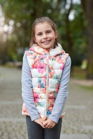 Smiling little girl standing outsideの写真素材