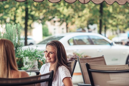 Woman chatting at a sidewalk cafeの写真素材
