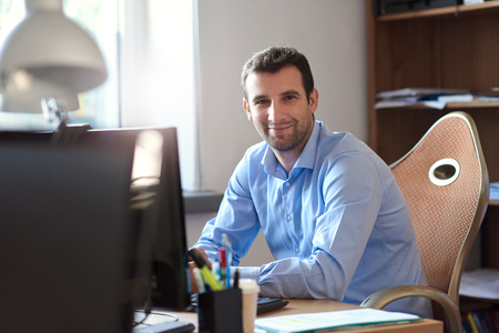 Smiling businessman at work in an officeの写真素材