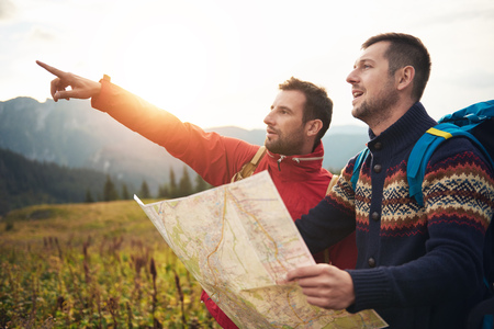 Hikers reading a trail map while trekking in the hillsの写真素材